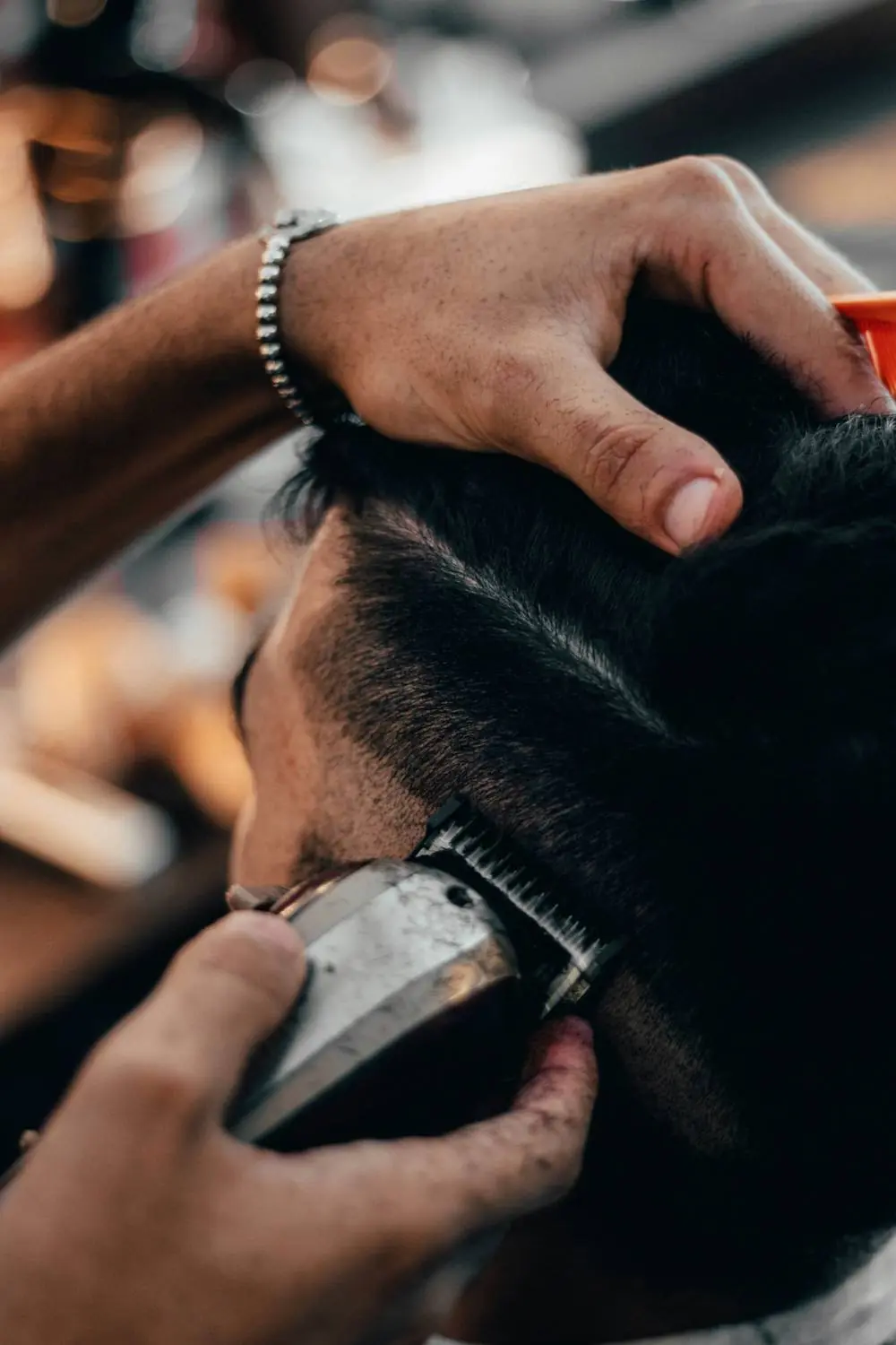 Ein Barbier schneidet einen Fade mit der Haarschneidemaschine